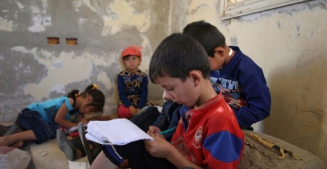 In abandoned villa, Syrian children study on the ground