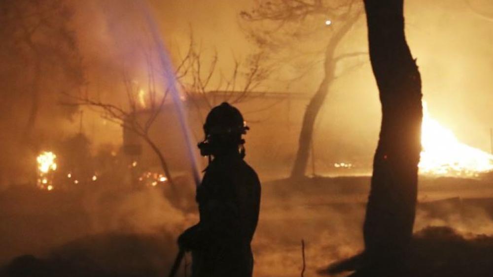 Greek wildfires kill 50; hugging bodies found near beach